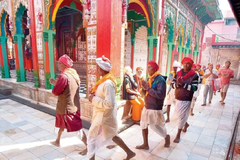 Parikrama — pilgrims walking a marked circuit road at first light, barefoot, in a continuous line