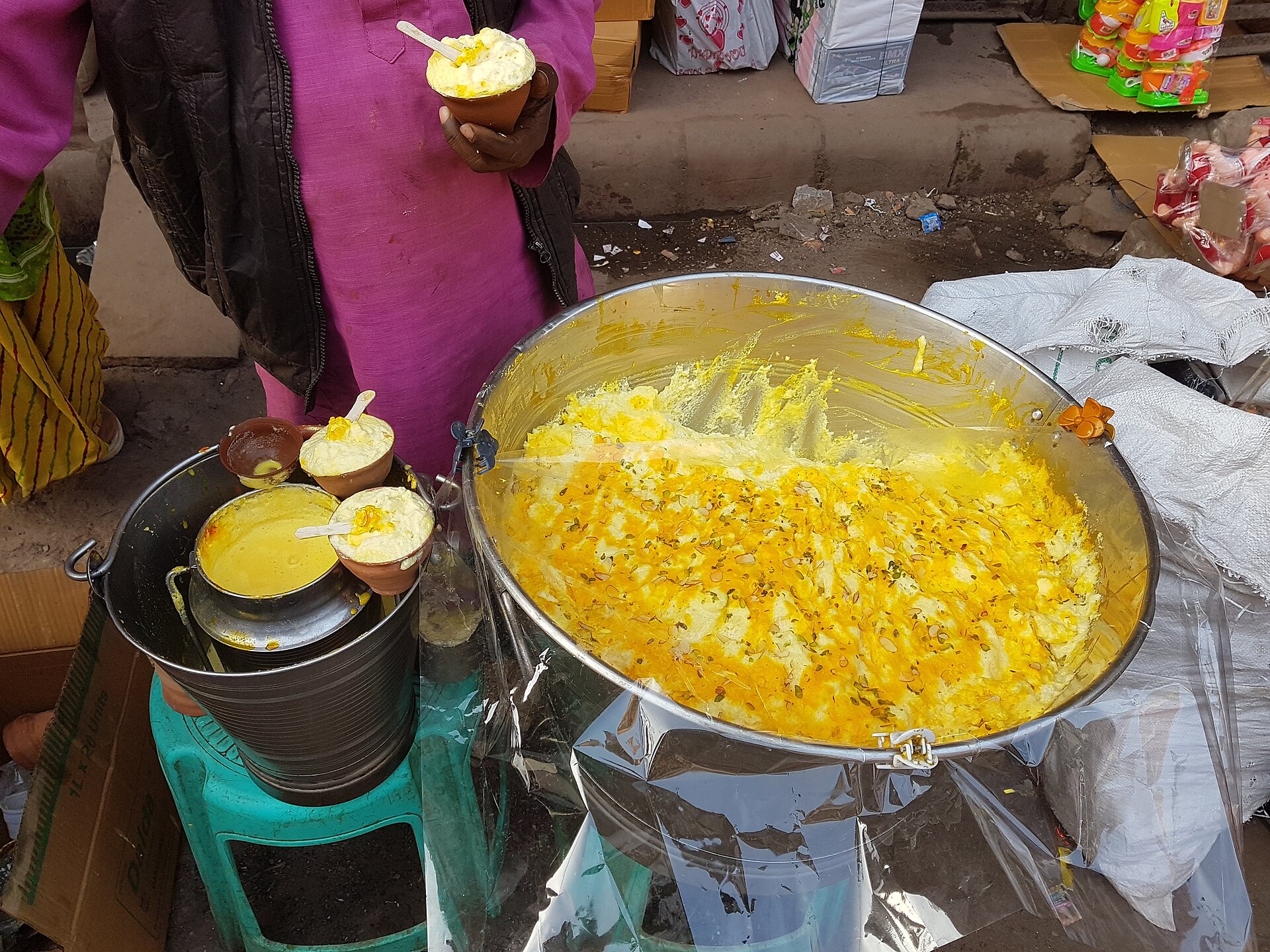 A Varanasi street vendor's pan of saffron-flecked malaiyo, served in small clay cups